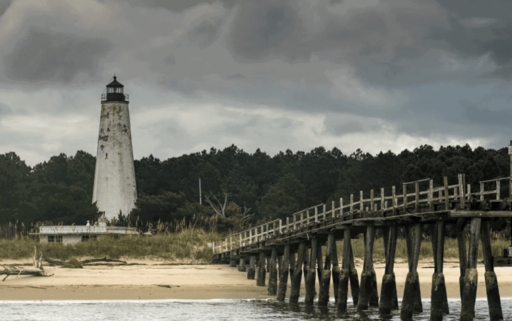 beach photography of pier and a lighthouse