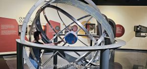 Adler Planetarium armillary sphere and Earth globe on Chicago’s Museum Campus in Chicago, Illinois, with a young visitor examining the Earth-centered astronomical model. Concentric rings illustrate celestial coordinates and the apparent movement of the Sun, connecting astronomy, navigation, geography and historical scientific observation – © 2026 David Oppenheimer – Performance Impressions photography archives https://performanceimpressions.com Adler Planetarium, Adler, Adler Chicago, Adler Planetarium Chicago, Chicago Adler, Adler museum, Adler astronomy, Adler Planetarium interior, Adler exhibit, Adler Planetarium exhibit, armillary sphere, armillary, sphere, Earth globe, globe, Earth, astronomical model, astronomy model, geocentric model, geocentric, Earth-centered, celestial sphere, celestial, celestial coordinates, ecliptic, celestial equator, astronomical instrument, scientific instrument, astronomy, planetarium, museum, science museum, astronomy museum, science, astronomy education, science education, STEM, education, learning, navigation, celestial navigation, geography, cartography, mapping, map, coordinates, latitude, longitude, Sun, solar path, cosmos, universe, astronomy history, historic astronomy, scientific history, concentric rings, rings, astronomy exhibit, science exhibit, museum exhibit, Astronomy in Culture, girl, child, young visitor, museum visitor, student, Chicago Museum Campus, Museum Campus, Museum Campus Chicago, Chicago museum, Chicago museums, Chicago astronomy, Chicago science, Chicago education, Chicago attraction, South Loop, South Loop Chicago, Chicago, Chicago Illinois, Illinois, 1300 South DuSable Lake Shore Drive, 1300 S DuSable Lake Shore Drive, DuSable Lake Shore Drive, 60605, Adler Planetarium and Astronomy Museum, Adler Planetarium & Astronomy Museum, United States, USA, museum photography, astronomy photography, science photography, educational photography, travel photography, editorial photography, licensing, image licensing, commercial imagery, photography licensing, art, print, fine art, commercial photography, David Oppenheimer, Performance Impressions, horizontal, 1-15213827141