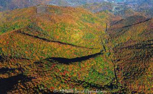 Vivid Autumn colors in the valley below Piney Field Top Mountain in Haywood County, North Carolina Aerial View