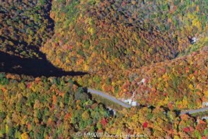 Blue Ridge Parkway winding through vibrant Autumn Foliage in the mountains of Western North Carolina Aerial View