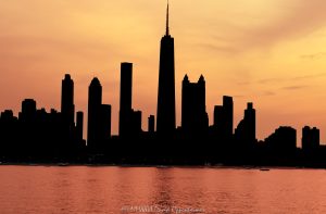 Chicago Gold Coast lakefront skyline silhouette at sunset from Lake Michigan, with Near North Side towers rising in dark profile against a fire-orange sky. The glowing lake surface reflects the post-sunset color as high-rises along North Michigan Avenue and North Lake Shore Drive frame the Chicago, Illinois lakefront – © 2026 David Oppenheimer – Performance Impressions photography archives https://performanceimpressions.com Chicago skyline silhouette, Chicago skyline, Chicago cityscape, cityscape, Chicago sunset, Gold Coast skyline, Lake Michigan, Chicago lakefront, Chicago waterfront, Chicago coastline, Chicago coast, skyline sunset, sunset skyline, orange sky, fire orange sky, orange sunset, sunset glow, glowing sky, glowing water, lake reflection, orange reflection, silhouetted skyline, building silhouettes, tower silhouettes, sunset silhouette, skyline art, Chicago art, Chicago photography, downtown Chicago, Near North Side, Gold Coast, Gold Coast Chicago, Streeterville, Magnificent Mile, Mag Mile, North Michigan Avenue, Michigan Avenue, North Lake Shore Drive, DuSable Lake Shore Drive, Oak Street Beach, Rush Street, Division Street, Rush and Division, Chicago, Chicago Illinois, Chicago IL, Illinois, 60611, skyline, urban skyline, cityscape, landscape, urban landscape, lake, water, lakefront, waterfront, coast, coastline, shoreline, horizon, sunset, dusk, twilight, after sunset, evening, evening light, clouds, cloudscape, architecture, buildings, skyscrapers, towers, high rise, office towers, residential towers, hotel towers, condominiums, apartments, hotels, mixed use, real estate, Chicago real estate, Gold Coast real estate, lakefront real estate, waterfront real estate, commercial real estate, residential real estate, 875 North Michigan Avenue, 875 N Michigan Avenue, 360 Chicago, 360 Chicago Observation Deck, John Hancock Center, former John Hancock Center, Water Tower Place, 835 North Michigan Avenue, 835 N Michigan Avenue, The Ritz-Carlton Chicago, Park Tower, Park Tower Chicago, 800 North Michigan Avenue, 800 N Michigan Avenue, Park Hyatt Chicago, Olympia Centre, Olympia Center, 737 North Michigan Avenue, 737 N Michigan Avenue, 900 North Michigan, 900 North Michigan Avenue, 900 North Michigan Shops, Bloomingdale’s, Bloomingdale’s Chicago, Four Seasons Hotel Chicago, Four Seasons, 132 East Delaware Residences, One Magnificent Mile, One Mag Mile, 950 North Michigan Avenue, 950 N Michigan Avenue, 1000 Lake Shore Plaza, 1000 N Lake Shore Plaza, The Carlyle, 1040 North Lake Shore Drive, 1040 N Lake Shore Drive, 1110 North Lake Shore Drive, 1110 N Lake Shore Drive, 1120 North Lake Shore Drive, 1120 N Lake Shore Drive, Skidmore Owings Merrill, SOM, Bruce Graham, Fazlur Rahman Khan, Kohn Pedersen Fox, KPF, Perkins Will, Lucien Lagrange, DeStefano Partners, Edward D Dart, Loebl Schlossman Bennett Dart, Robert DeGolyer, skyline photography, cityscape photography, landscape photography, architectural photography, sunset photography, lakefront photography, Chicago skyline art, Chicago cityscape art, sunset art, landscape art, wall art, art print, Chicago print, skyline print, fine art print, travel, tourism, destination, United States, licensing, image licensing, commercial imagery, photography licensing, art, print, fine art, commercial photography, David Oppenheimer, horizontal, 1-15213827141