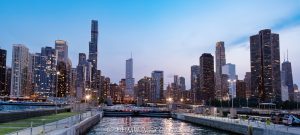 Chicago Harbor Lock in Chicago, Illinois, connects Lake Michigan with the Chicago River beneath the downtown skyline after sunset. City lights line the waterfront under a blue-hour sky, with navigation lights marking the lock and the breakwater visible at the Chicago Harbor entrance – © 2026 David Oppenheimer – Performance Impressions photography archives https://performanceimpressions.com Chicago Harbor Lock, Chicago Harbor, Chicago Lock, Chicago River Lock, Chicago Harbor entrance, Lake Michigan, Chicago River, river mouth, Chicago skyline, Chicago cityscape, downtown Chicago, Chicago lakefront, Chicago waterfront, Chicago, Chicago Illinois, Chicago IL, Illinois, 60611, sunset, Chicago sunset, blue hour, twilight, dusk, evening, lights, city lights, skyline lights, building lights, navigation lights, illuminated skyline, sunset sky, clouds, cloudscape, dramatic sky, skyline, cityscape, landscape, downtown, city, urban, buildings, skyscrapers, towers, architecture, lake, water, river, harbor, harbor lock, navigation lock, lock, navigation, maritime, waterway, channel, breakwater, jetty, lock gates, infrastructure, lakefront, waterfront, shoreline, horizon, United States, licensing, image licensing, commercial imagery, photography licensing, art, print, fine art, commercial photography, David Oppenheimer, horizontal, 1-15213827141