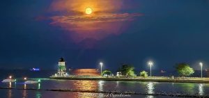 Full moon rising above the Chicago Harbor Southeast Guidewall Lighthouse marks the Lake Michigan entrance to the Chicago River, viewed from Offshore Rooftop at Navy Pier. The harbor channel, guidewall and breakwater lead through the scene with several boats on the water, creating a layered Chicago waterfront composition in Chicago, Illinois – © 2026 David Oppenheimer – Performance Impressions photography archives https://performanceimpressions.com Chicago Harbor Southeast Guidewall Lighthouse, Chicago Harbor Southeast Guidewall Light, Chicago Harbor Southeast Guidewall, Southeast Guidewall Lighthouse, Chicago guidewall lighthouse, Chicago lighthouse, Lake Michigan lighthouse, full moon, full moon rising, moonrise, moon, lunar, moonlight, moonlit, glowing moon, moon photography, lunar photography, full moon photography, moon over lighthouse, full moon lighthouse, lighthouse moon, lighthouse, harbor lighthouse, guidewall light, navigation light, navigation aid, beacon, harbor beacon, lighthouse photography, Chicago Harbor, Chicago harbor entrance, Chicago River entrance, Chicago River mouth, Chicago River, Lake Michigan, Great Lakes, Chicago lakefront, Chicago waterfront, lakefront, waterfront, harbor, channel, harbor channel, navigation channel, guidewall, south guidewall, southeast guidewall, breakwater, breakwater structure, harbor entrance, maritime navigation, marine navigation, boating, boats, moored boats, anchored boats, recreational boats, pleasure boats, Offshore Rooftop, Offshore Rooftop Chicago, Offshore Chicago, Offshore Rooftop & Bar, Navy Pier, Navy Pier Chicago, 1000 East Grand, 1000 E Grand Ave, Festival Hall, Chicago rooftop, rooftop, rooftop view, Streeterville, Streeterville Chicago, Near North Side, downtown Chicago, Chicago, Chicago Illinois, Chicago IL, Illinois, 60611, Chicago Harbor Lock, Chicago Lock, harbor lock, navigation lock, lock, USACE, U.S. Army Corps of Engineers, US Army Corps of Engineers, USACE Chicago District, Chicago District, Illinois Waterway, U.S. Coast Guard, US Coast Guard, USCG, maritime, nautical, waterfront photography, harbor photography, maritime photography, nautical photography, landscape photography, urban landscape, fine art photography, art photography, contemporary photography, creative photography, surreal photography, surreal, surrealism, photorealism, photo realism, photorealistic, painterly, painterly photography, lighthouse art, lighthouse print, lighthouse wall art, moon art, full moon art, lunar art, moon print, moon wall art, nautical art, maritime art, harbor art, Lake Michigan art, Chicago art, Chicago photography, Chicago wall art, Navy Pier art, fine art print, photographic print, archival print, gallery print, collector print, collectible art, art print, wall art, wall decor, luxury decor, home decor, office decor, interior design, statement art, art collector, photography collector, lighthouse collector, Maverick Hotels & Restaurants, Maverick Hotels and Restaurants, Navy Pier Inc, United States, licensing, image licensing, commercial imagery, photography licensing, art, print, fine art, commercial photography, David Oppenheimer, horizontal, 1-15213827141