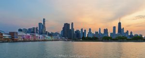 Navy Pier stretches across the foreground of a Lake Michigan view, with the Centennial Wheel, shops, restaurants, and lakefront attractions set against the Chicago skyline silhouetted at sunset. Designed by Charles S. Frost, the historic landmark in Chicago, Illinois, originally opened as Municipal Pier No. 2 – © 2026 David Oppenheimer – Performance Impressions photography archives https://performanceimpressions.com Navy Pier, Chicago skyline, Navy Pier Chicago, Centennial Wheel, Navy Pier Centennial Wheel, Centennial Ferris Wheel, Navy Pier Ferris wheel, Chicago Ferris wheel, Ferris wheel, observation wheel, Pier Park, gondolas, Chicago skyline sunset, Navy Pier sunset, Chicago Harbor, Lake Michigan, Chicago cityscape, Chicago sunset, Chicago lakefront, Chicago waterfront, 600 East Grand Avenue, 600 E Grand Ave, East Grand Avenue, Streeterville, Near North Side, downtown Chicago, Chicago, Chicago Illinois, Chicago IL, Illinois, 60611, skyline, cityscape, sunset, pier, lake, water, harbor, lakefront, waterfront, shoreline, horizon, silhouette, skyline silhouette, building silhouettes, sunset silhouette, evening, twilight, dusk, sunset sky, evening sky, golden light, city, urban, buildings, skyscrapers, towers, architecture, landscape, Municipal Pier No. 2, Municipal Pier 2, Municipal Pier, Charles Sumner Frost, Charles S Frost, Daniel Burnham, Plan of Chicago, historic pier, lakefront landmark, Chicago icon, waterfront architecture, historic architecture, tourism, travel, destination, recreation, entertainment, skyline photography, sunset photography, cityscape photography, landscape photography, architectural photography, Chicago art, ride, Wheel, skyline art, United States, licensing, image licensing, commercial imagery, photography licensing, art, print, fine art, commercial photography, David Oppenheimer, horizontal, 1-15213827141