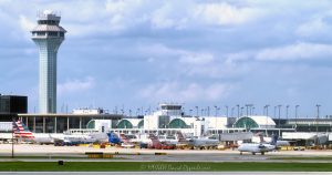 ATC Tower and American Airlines Terminal 3 at Chicago O’Hare Airport in Chicago, Illinois, shown from the tarmac with aircraft, gates, jet bridges, taxiways, and terminal architecture. Daytime view of American Airlines and American Eagle operations near Terminal 3 Concourse G, including arched roof structures, commercial aircraft, and airport ramp activity – © 2026 David Oppenheimer – Performance Impressions photography archives https://performanceimpressions.com Chicago O’Hare International Airport, O’Hare International Airport, O’Hare Airport, Chicago O’Hare, O’Hare, ORD, ORD Airport, Chicago airport, airport, ATC tower, air traffic control tower, control tower, FAA tower, airport tower, American Airlines, American Airlines jets, AA, AA jets, American Eagle, aircraft, airplane, airplanes, jet, jets, passenger jet, commercial aircraft, Terminal 3, Terminal 3 Concourse G, Concourse G, terminal concourse, airport terminal, airline terminal, passenger terminal, terminal, terminal building, terminal architecture, arched roof, airport architecture, aviation, commercial aviation, airline, airlines, airport operations, airline operations, ground operations, airport ramp, ramp area, airport tarmac, tarmac, airport apron, taxiway, jet bridge, gate area, airport gate, aircraft gates, airport infrastructure, aviation infrastructure, airport scene, air travel, travel, transportation, transportation infrastructure, modern architecture, urban infrastructure, Chicago, Chicago Illinois, Illinois, United States, 60666, daytime, city airport, Midwest aviation, aviation industry, transportation hub, hub airport, O’Hare terminal, O’Hare tower, photorealism, photorealistic, digital art, artwork, rich color, saturated color, commercial photography, commercial imagery, image licensing, licensing, photography licensing, David Oppenheimer, horizontal, 1-15156784411