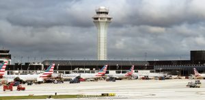Chicago O’Hare International Airport Terminal 3 with American Airlines jets parked at the K gates beneath dark clouds, with the jet bridges, the airport apron, and an air traffic control tower in the background. The terminal section at the left edge houses the American Airlines flagship lounge, the Admirals Club – © 2026 David Oppenheimer – Performance Impressions photography archives https://performanceimpressions.com Chicago O’Hare International Airport, Chicago O’Hare Airport, O’Hare International Airport, O’Hare Airport, Chicago O’Hare, Chicago airport, ORD, O’Hare Terminal 3, Chicago O’Hare Terminal 3, Terminal 3, Terminal 3 Chicago, American Airlines jets, American Airlines O’Hare, American Airlines ORD, American Airlines Terminal 3, O’Hare K gates, Terminal 3 K gates, K gates, Concourse K, K Concourse, 10000 W O’Hare Avenue, 10000 West O’Hare Avenue, O’Hare, O’Hare Chicago, O’Hare community area, Northwest Side Chicago, Chicago Illinois, Chicago IL, 60666, Orchard Field, former Orchard Field, airport, terminal, airport terminal, gates, airport gates, boarding gates, gate area, aviation, commercial aviation, air travel, airline, airlines, jet, jets, aircraft, airplanes, airliners, passenger jets, passenger aircraft, commercial aircraft, parked jets, parked aircraft, aircraft parking, American Airlines, American, American Airlines Group, AAdvantage, Oneworld, American Airlines hub, airline hub, hub airport, American Airlines fleet, American Airlines livery, aircraft tails, jet bridge, jet bridges, apron, airport apron, ramp, airport ramp, tarmac, ground operations, airline operations, airport operations, airfield, terminal building, terminal exterior, airport exterior, building exterior, facade, air traffic control, air traffic control tower, airport control tower, control tower, ATC, ATC tower, O’Hare control tower, FAA, Federal Aviation Administration, Chicago Department of Aviation, CDA, American Airlines Flagship Lounge, American Flagship Lounge, Flagship Lounge, Flagship Lounge ORD, American Airlines Admirals Club, Admirals Club, Admirals Club ORD, Admirals Club lounge, American Airlines lounge, Terminal 3 lounge, H K connector, dark clouds, cloudy sky, overcast sky, cloud cover, weather, airport weather, aviation weather, dramatic sky, airport architecture, terminal architecture, transportation architecture, airport photography, aviation photography, transportation, travel, business travel, Chicago aviation, Illinois aviation, United States, licensing, image licensing, commercial imagery, photography licensing, art, print, fine art, commercial photography, David Oppenheimer, horizontal, 1-15213827141