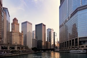 Chicago River architecture and skyline in late-day light, with downtown towers lining both banks as sunlight reflects from glass facades across the water. Viewed from a Chicago River architecture cruise, the scene includes the Riverwalk and a tour boat moving through the dense riverfront cityscape of Chicago, Illinois – © 2026 David Oppenheimer – Performance Impressions photography archives https://performanceimpressions.com Chicago River architecture, Chicago River skyline, Chicago architecture cruise, Chicago River cruise, Chicago River, Chicago Riverwalk, Riverwalk, Wacker Drive, Wacker Drive architecture, downtown Chicago, Chicago skyline, Chicago cityscape, River North, Chicago Loop, Loop Chicago, Chicago, Chicago Illinois, Chicago IL, Illinois, 60601, 60611, 35 West Wacker, 35 W Wacker Drive, Leo Burnett Building, Leo Burnett, 35 East Wacker, 35 E Wacker Drive, Jewelers Building, Pure Oil Building, North American Life Building, 77 West Wacker, 77 W Wacker Drive, RR Donnelley Building, United Building, OneEleven, One Eleven, 111 West Wacker, 111 W Wacker Drive, Waterview Tower, Trump International Hotel & Tower Chicago, Trump Tower Chicago, Trump Tower, 401 N Wabash Avenue, Wendella Linnea, Linnea, Wendella Boats, Richard J Cady Memorial River Lookout, river lookout, O'Brien's Riverwalk Cafe, riverwalk cafe, skyline, cityscape, architecture, river, water, riverfront, waterfront, downtown, urban, buildings, towers, skyscrapers, high rises, office towers, office buildings, commercial buildings, glass towers, facade, glass facade, reflective glass, sunlight, sun rays, late afternoon, golden hour, reflections, river reflection, sunlit buildings, urban canyon, river view, boat, riverboat, tour boat, boat tour, river cruise, architecture tour, architecture cruise, Chicago boat tour, tourism, travel, destination, Chicago photography, skyline photography, cityscape photography, architectural photography, urban photography, Chicago art, skyline art, cityscape art, urban art, artwork, wall art, art print, Chicago print, real estate, Chicago real estate, commercial real estate, office real estate, riverfront real estate, Skidmore Owings Merrill, SOM, Adrian Smith, William F Baker, Roche Dinkeloo, Kevin Roche, Giaver & Dinkelberg, Ricardo Bofill, Handel Architects, Related Midwest, Publicis Groupe, Trump Organization, United States, licensing, image licensing, commercial imagery, photography licensing, art, print, fine art, commercial photography, David Oppenheimer, horizontal, 1-15213827141