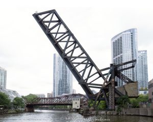 Chicago and North Western Railway Kinzie Street Bridge raised over the North Branch of the Chicago River in downtown Chicago, Illinois. Historic single-leaf bascule railroad bridge near Kinzie Street and Canal Street, also known as the Carroll Avenue Bridge, built in 1908 and designated a Chicago Landmark in 2007. The raised steel bridge is a former Chicago and North Western railroad span now owned by Union Pacific – © 2026 David Oppenheimer – Performance Impressions photography archives https://performanceimpressions.com Chicago and North Western Railway Bridge, Chicago & North Western Railway Bridge, Chicago and North Western Railroad Bridge, Chicago & North Western Railroad Bridge, Kinzie Street railroad bridge, Kinzie Street Railroad Bridge, Kinzie Street Bridge, Carroll Avenue Bridge, C&NW bridge, C&NW railroad bridge, Union Pacific bridge, Union Pacific Railroad, raised bridge, bridge, raised railroad bridge, open bridge, bascule bridge, single-leaf bascule bridge, railroad bridge, railway bridge, rail bridge, train bridge, steel bridge, steel girders, bridge girders, metal girders, steel truss, truss bridge, railroad truss, steel structure, bridge structure, riveted steel, steelwork, historic bridge, landmark bridge, Chicago Landmark, Chicago bridge, Chicago bridges, Chicago railroad bridge, Chicago railway bridge, Chicago River bridge, Chicago River, North Branch Chicago River, North Branch, Kinzie Street, Canal Street, Wolf Point, downtown Chicago, Chicago Loop, River North, Near West Side, Chicago, Chicago Illinois, Illinois, United States, 60654, architecture, Chicago architecture, architectural photography, bridge architecture, engineering, civil engineering, structural engineering, industrial architecture, transportation, transportation infrastructure, rail infrastructure, railroad infrastructure, railway infrastructure, railroad history, railway history, Chicago history, industrial history, historic infrastructure, urban infrastructure, bridge photography, railroad photography, rail photography, infrastructure photography, documentary photography, editorial photography, commercial photography, commercial imagery, image licensing, licensing, photography licensing, David Oppenheimer, horizontal, 1-15156784411