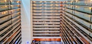 Embassy Suites by Hilton Chicago Downtown Magnificent Mile Atrium Interior Embassy Suites by Hilton Chicago Downtown Magnificent Mile atrium interior in Streeterville, Chicago, Illinois, showing three sides of the vast open central volume with approximately a dozen visible levels of stacked guestroom corridors and walkways. Repeating railings, floor edges and strong horizontal and vertical lines create an almost abstract geometric composition emphasizing the hotel’s multi-story atrium architecture and contemporary Art Deco-influenced design – © 2026 David Oppenheimer – Performance Impressions photography archives https://performanceimpressions.com