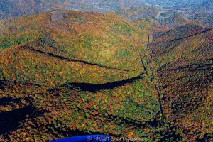 Vivid Autumn colors in the valley below Piney Field Top Mountain in Haywood County, North Carolina Aerial View