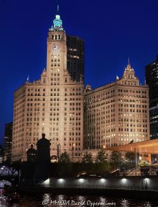 The Wrigley Building Lit Up at Night Along the Chicago River The Wrigley Building at 400–410 North Michigan Avenue glows above the Chicago River at night, its white glazed terra cotta facade, clock tower, and illuminated riverfront profile reflected in the water near DuSable Bridge. Designed by Graham, Anderson, Probst & White for William Wrigley Jr., the former Wrigley Company headquarters remains one of Chicago, Illinois’s defining landmarks on the Magnificent Mile – © 2026 David Oppenheimer – Performance Impressions photography archives https://performanceimpressions.com